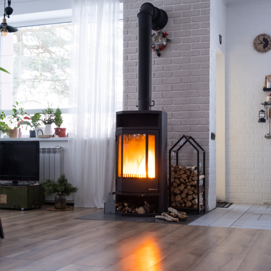 Black stove, fireplace in interior of house in loft style. Alternative eco-friendly heating, warm cozy room at home, burning wood Black stove, fireplace in interior of house in loft style. Alternative eco-friendly heating, warm cozy room at home, burning wood<br />